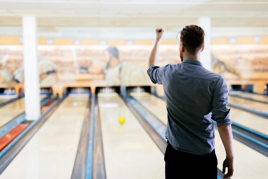 А man with a clenched fist celebrates a bowling hit