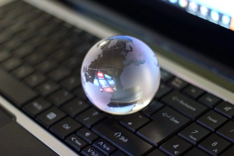 Glass globe on laptop keyboard.