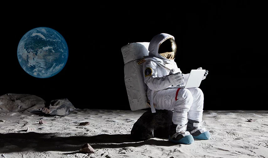 Astronauts sit on the moon and the Earth is behind.