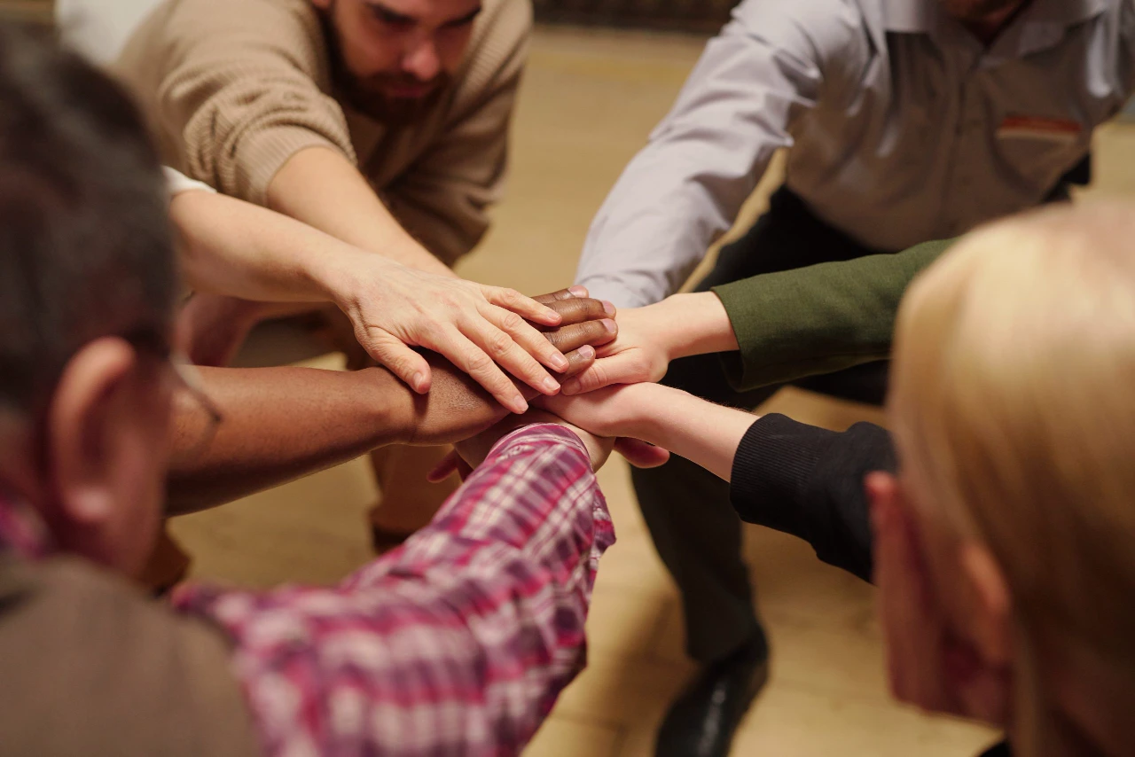 Pile of hands made up of several people of various ethnicities